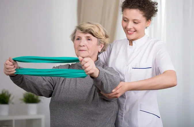 Mevrouw doet oefeningen met een fysiotherapeut tegen een rughernia.