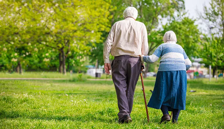 Een oudere vrouw ervaart pijn en andere symptomen door overbelasting van haar knieën.