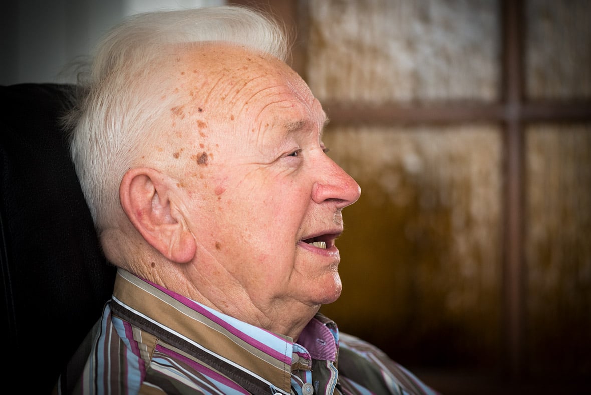 Meneer Rhijnsburger loopt moeilijk door een stoma, met de traplift gaat hij naar boven.