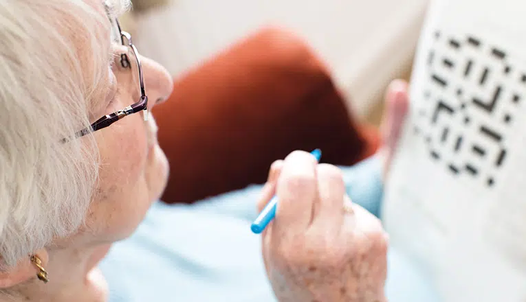 Een oudere vrouw maakt een geheugenpuzzel om haar geheugen te trainen