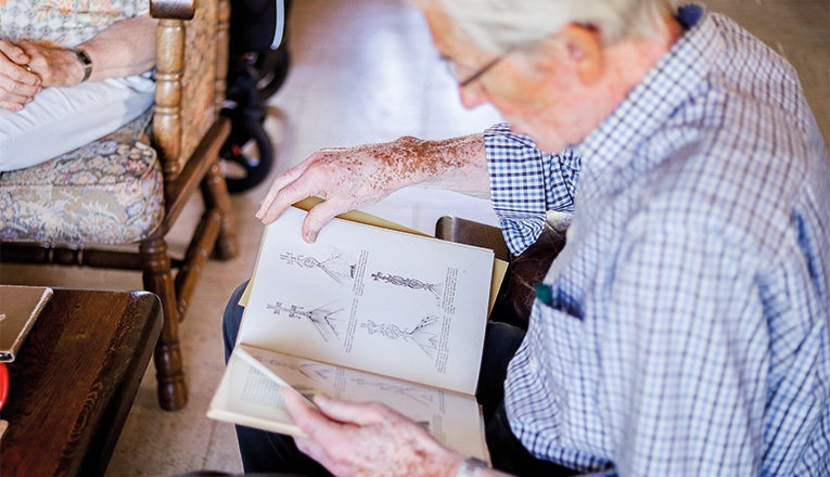 Meneer Kamphuis met boek vol geveltekens