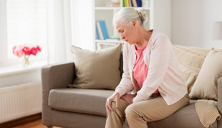 Een oudere vrouw heeft door spinocerebellaire ataxie last van spanning in haar spieren.