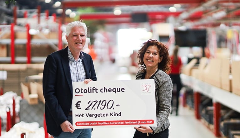 In de fabriek van Koninklijke Otolift ontvangt Jeroen van Woudenberg (Het Vergeten Kind) een cheque van € 27.190,- uit handen van Yvonne Dijkstra (Otolift Trapliften).