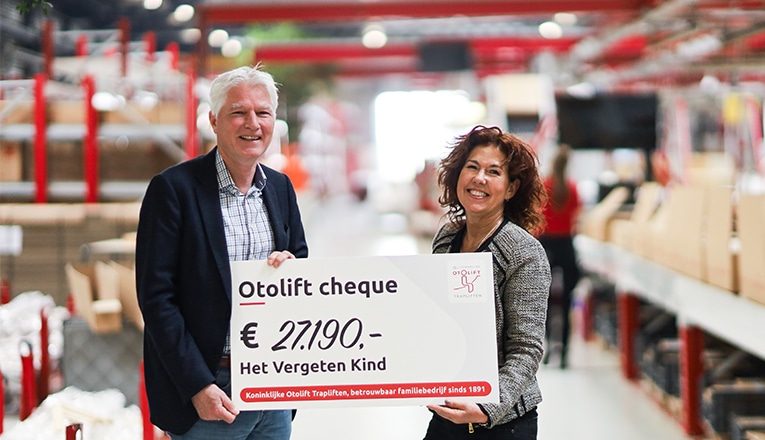 In de fabriek van Koninklijke Otolift ontvangt Jeroen van Woudenberg (Het Vergeten Kind) een cheque van € 27.190,- uit handen van Yvonne Dijkstra (Otolift Trapliften).